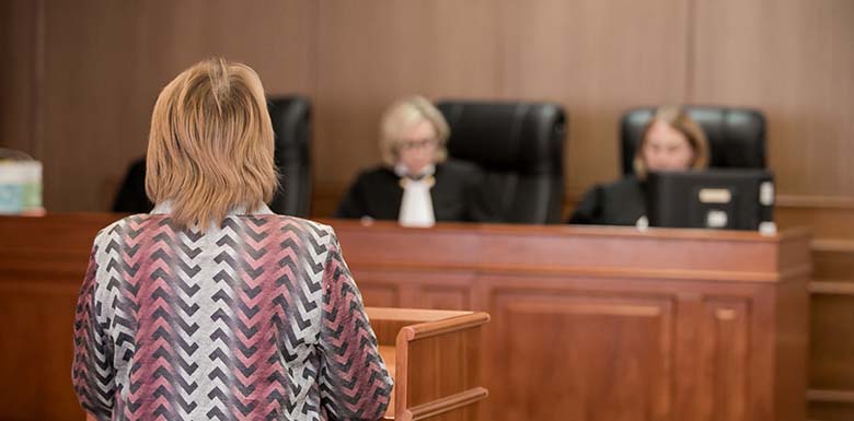 Woman speaking to panel of judges in court