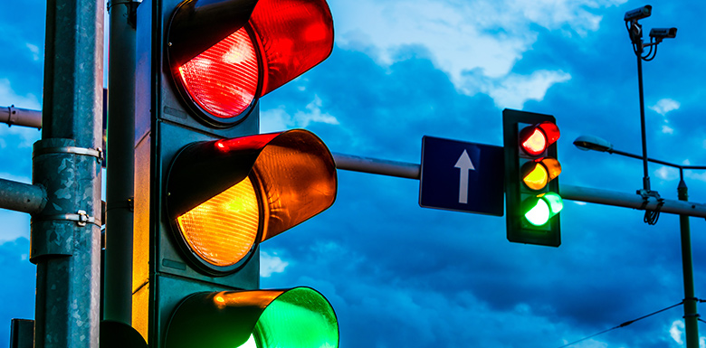 Close up view of traffic light signal against blue cloudy sky