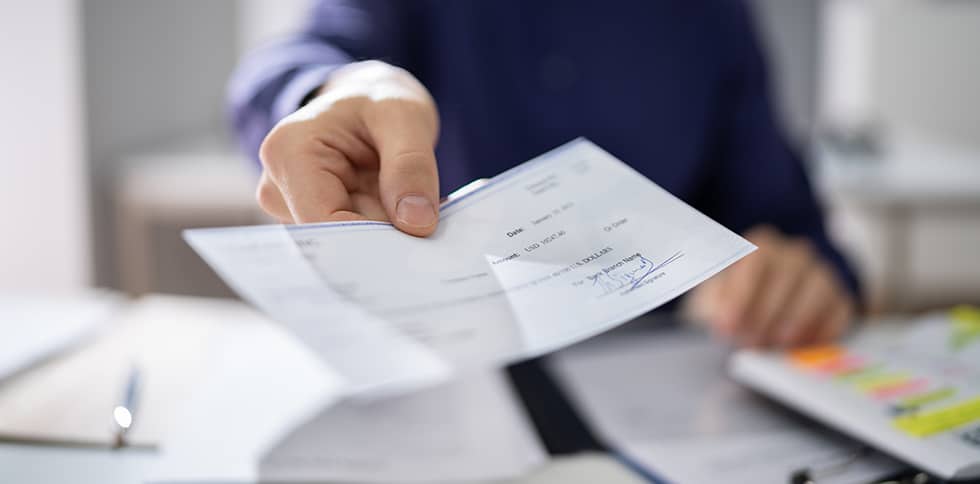 Man handing paycheck to person