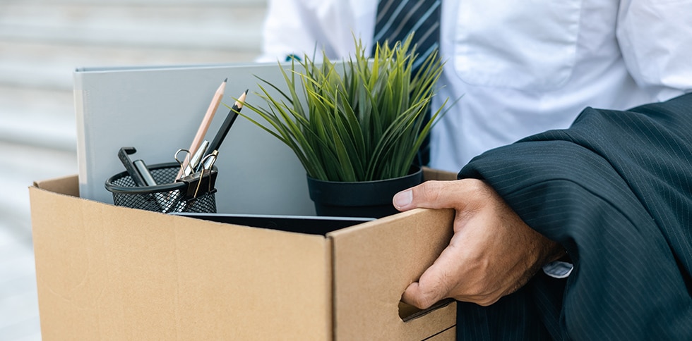 Man carrying box filled with office supplies