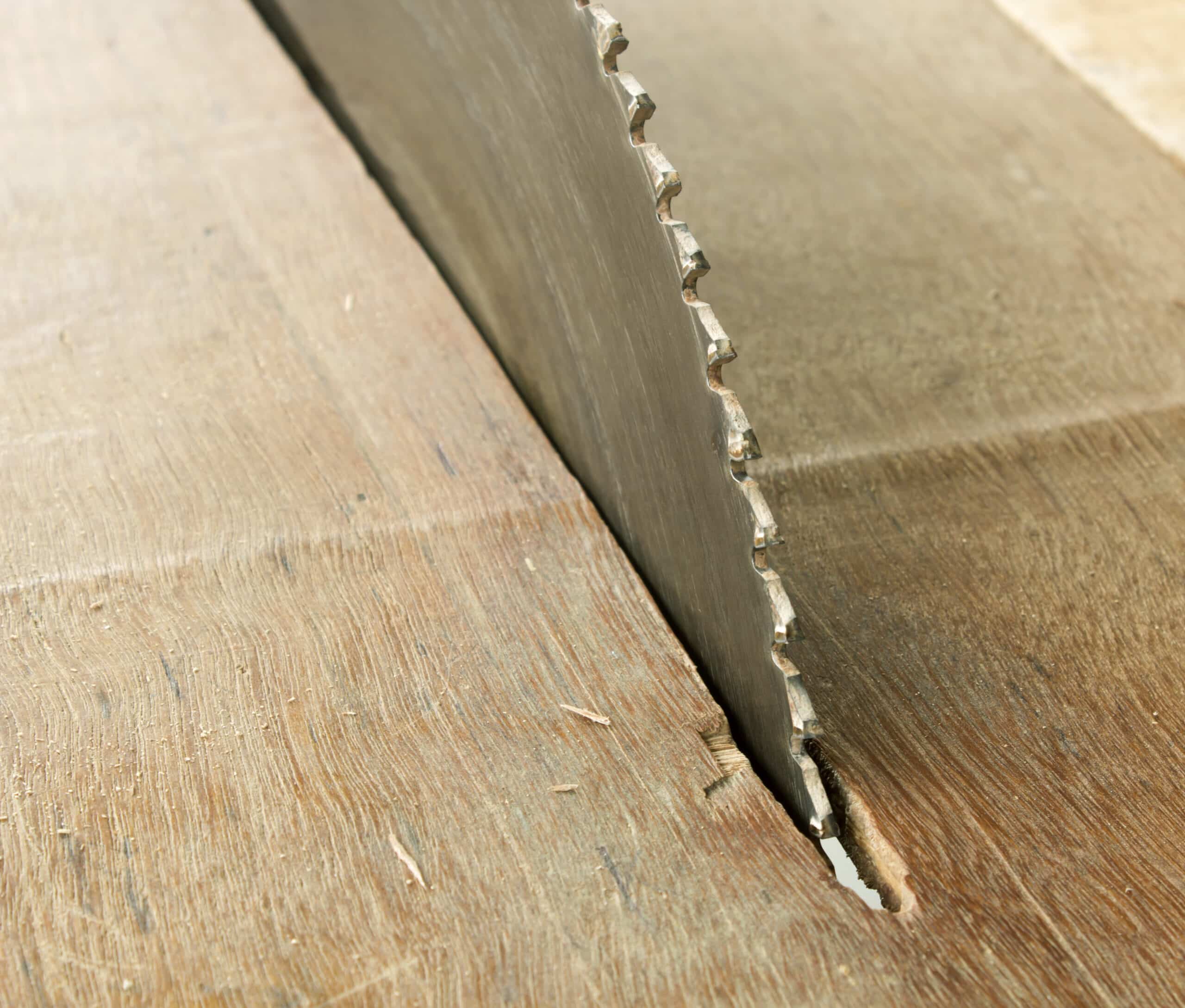 Close-up of an exposed table saw blade without a safety guard—an all-too-common cause of serious saw injuries in NYC construction accidents.